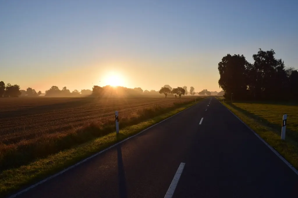Sun rising over an empty country road